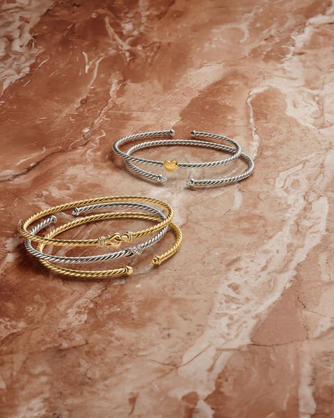 A stack of gold and silver bracelets.