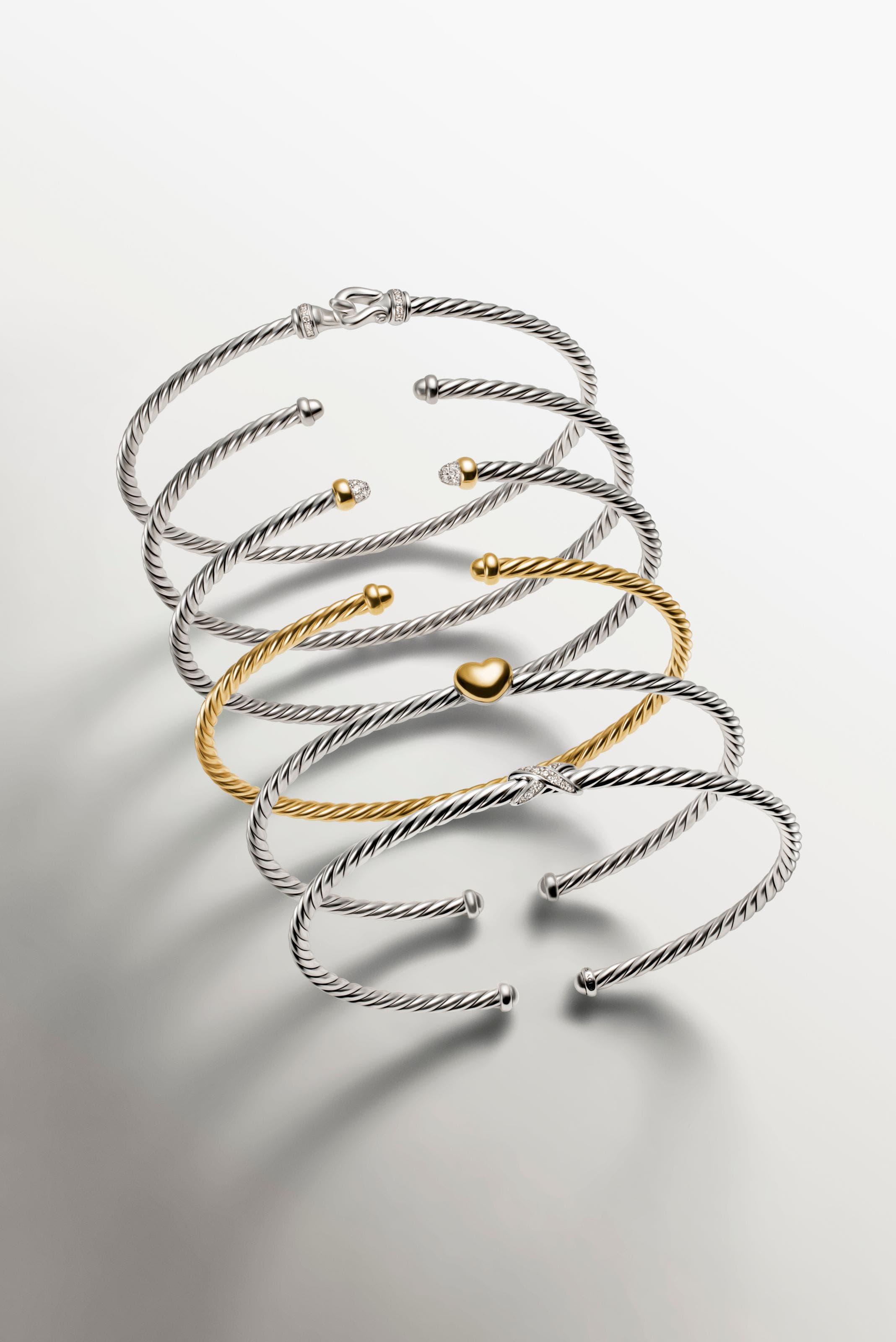 A stack of gold and silver bracelets.