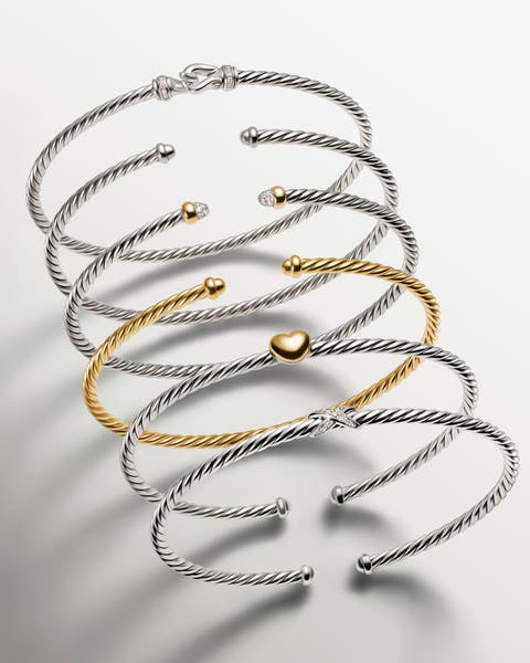 A stack of gold and silver bracelets.