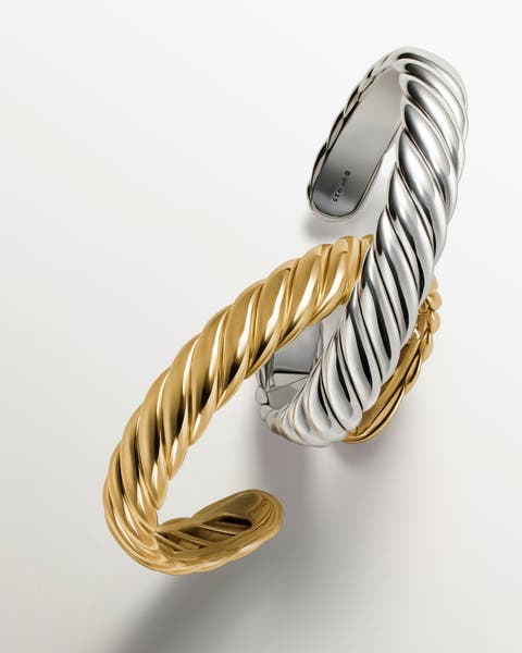A gold and a silver cuff bracelet.