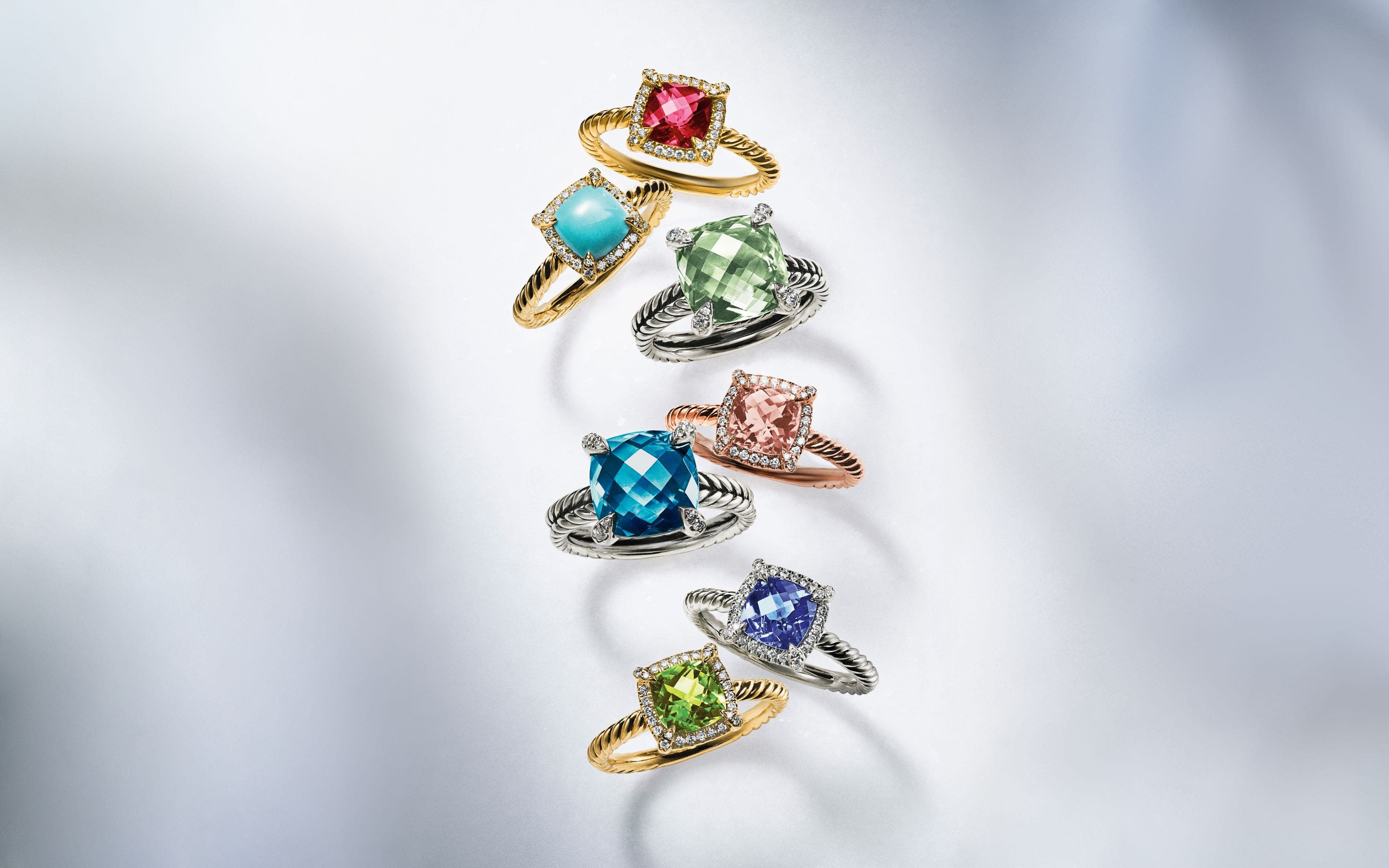 Silver and gold rings with a variety of colorful stones.