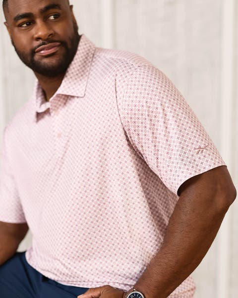 A man wearing a pink Reebok polo shirt.