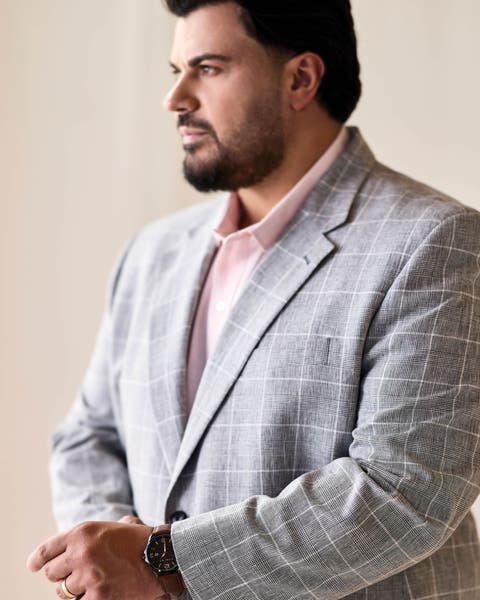 A man wearing a grey plaid sport coat.