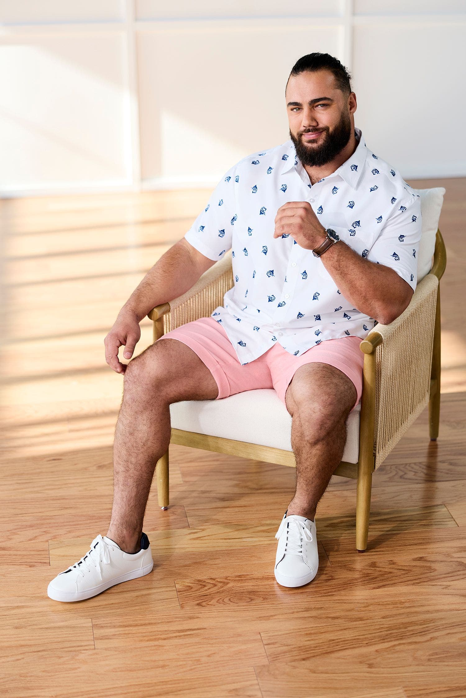 Man wearing a button-up shirt and pink shorts.