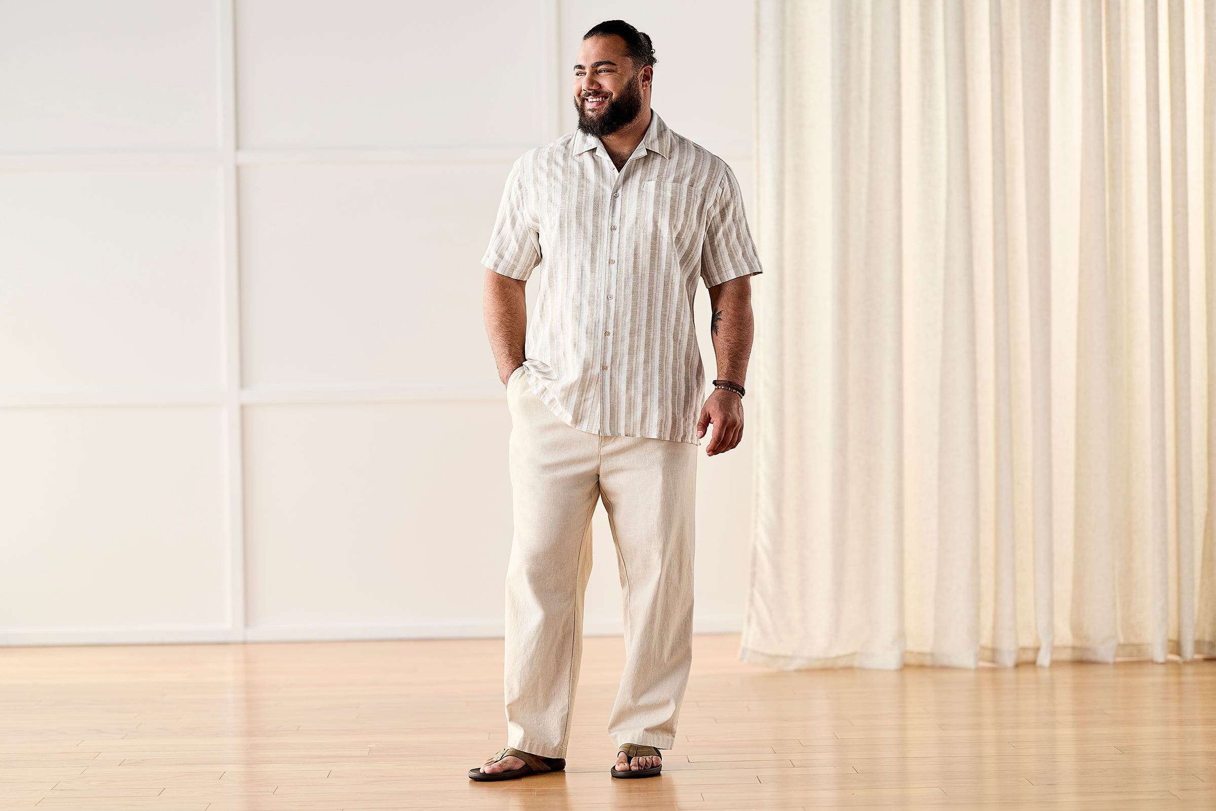 Man wearing linen button-up shirt, pants and sandals.
