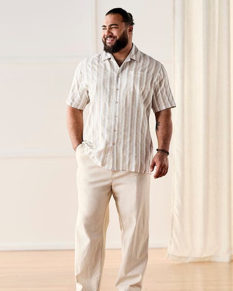 Man wearing linen button-up shirt, pants and sandals.