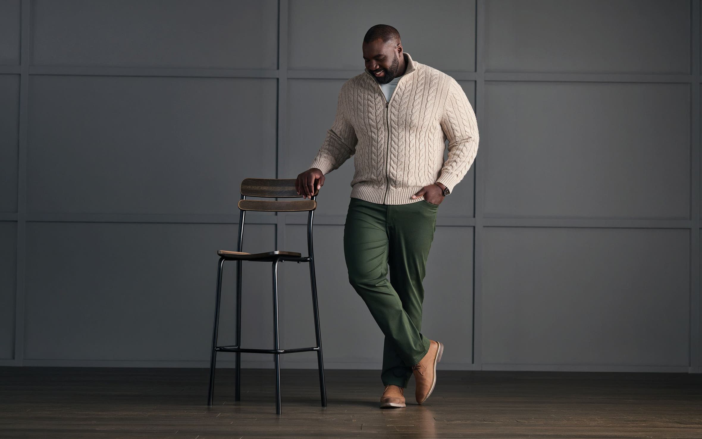 Man in cable-knit sweater and chinos.