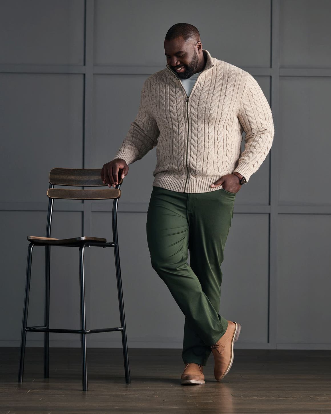 Man in cable-knit sweater and chinos.
