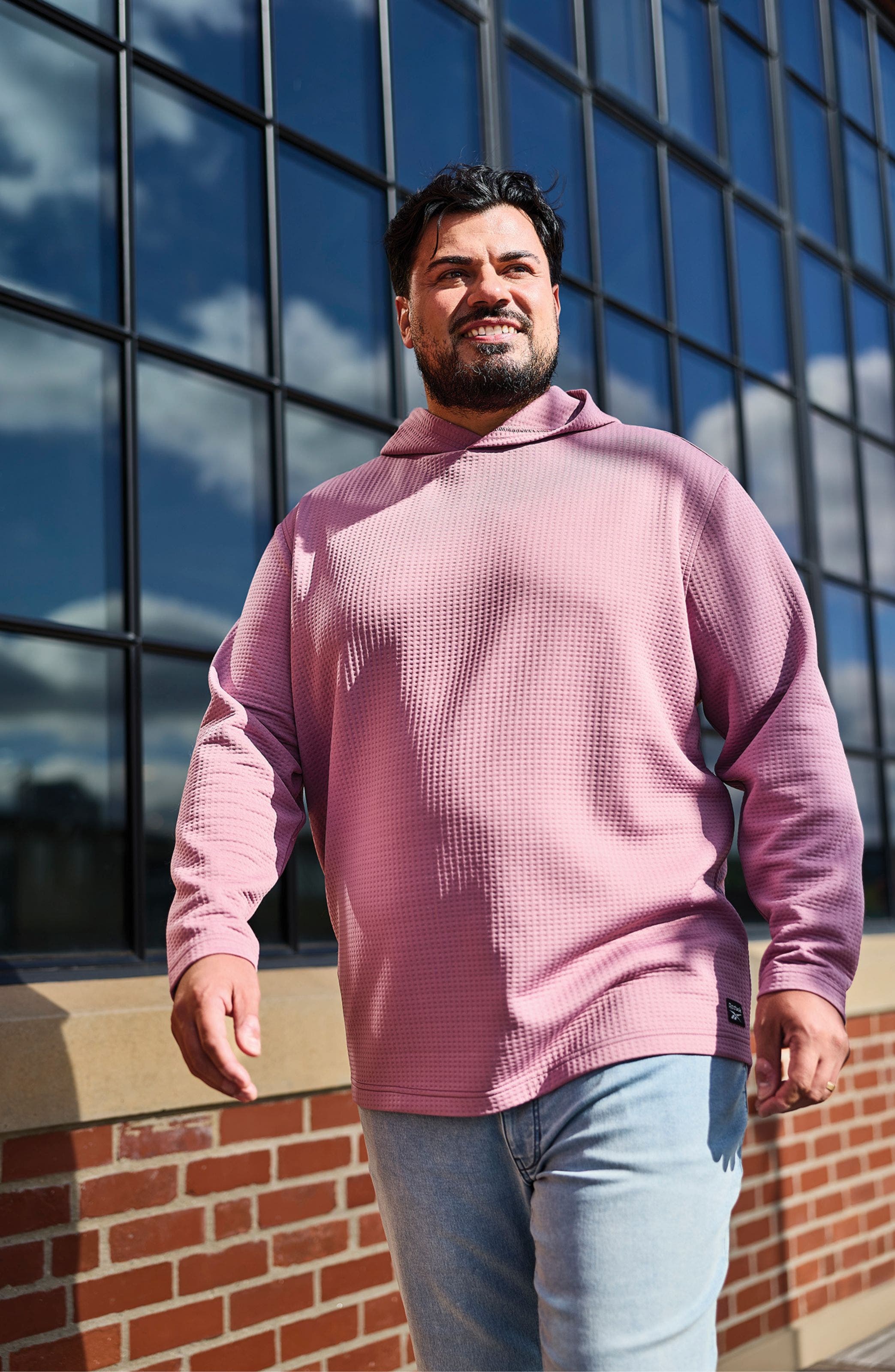 A man wearing a lilac-colored hoodie.