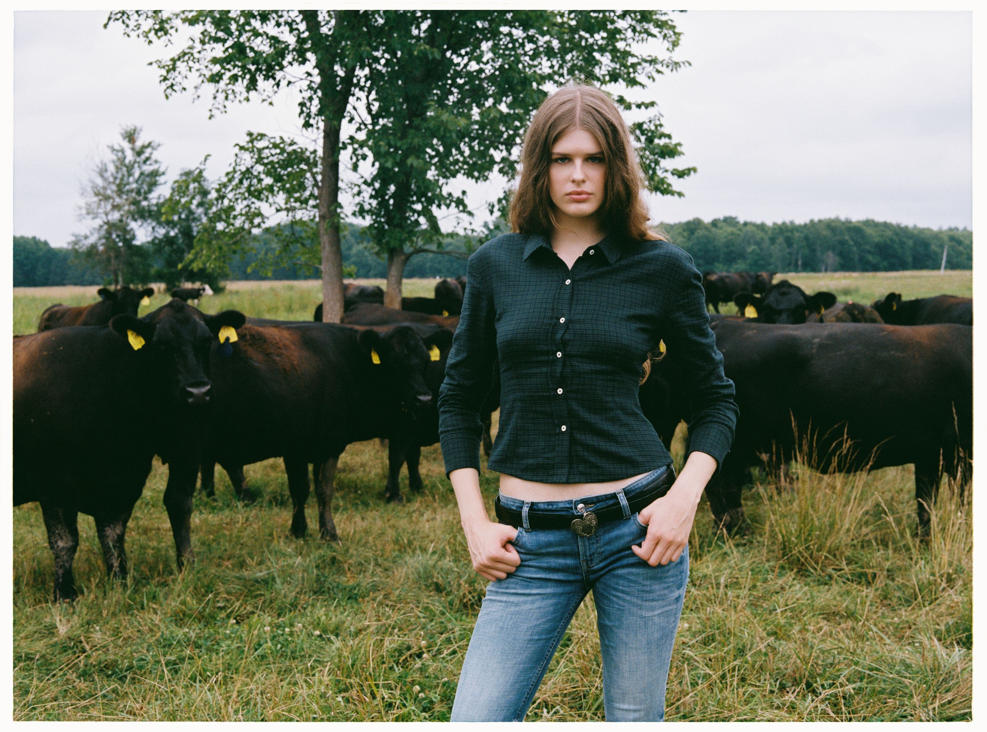 A woman wearing a button up shirt and a pair of low-rise denim.