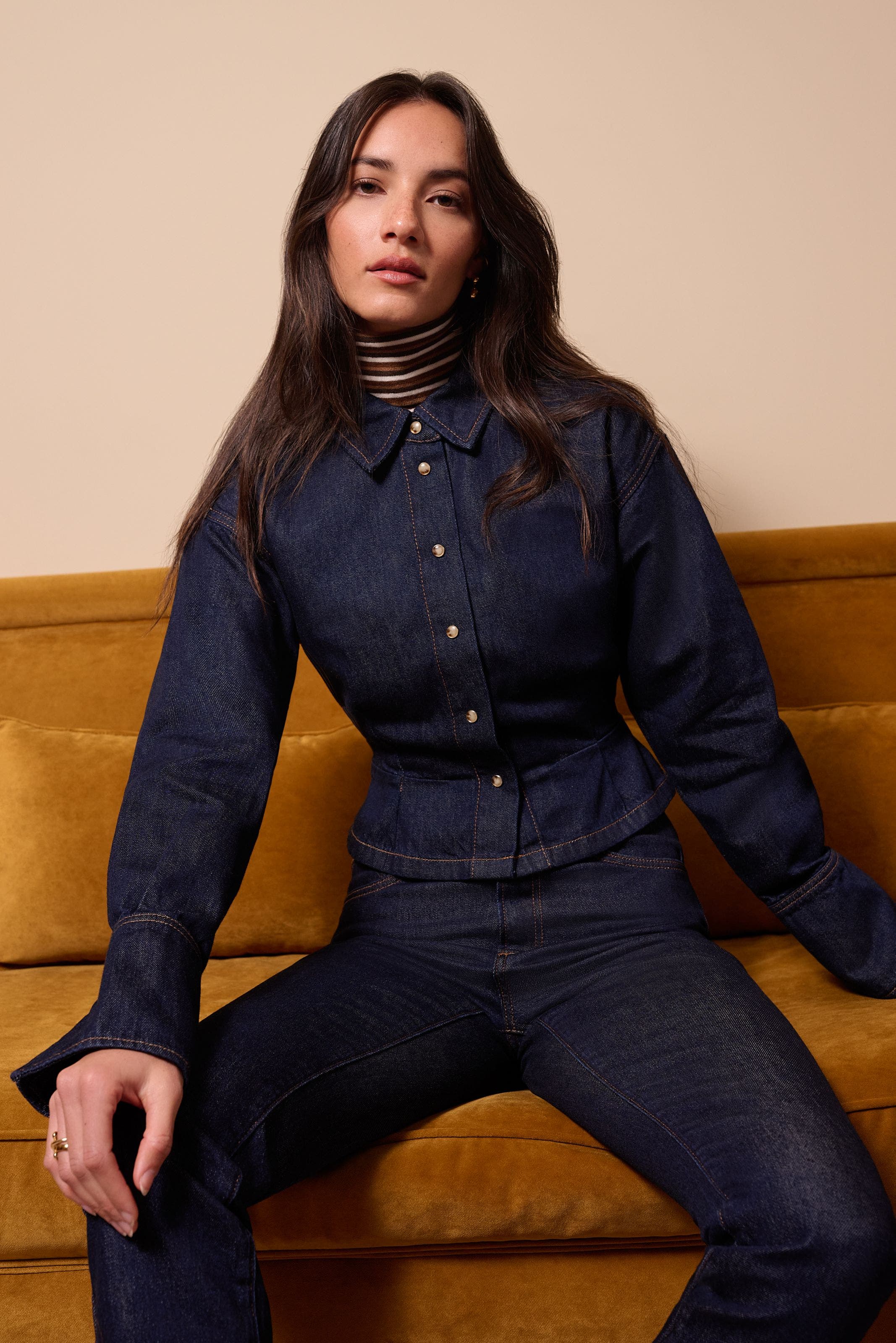 A woman wearing a long sleeve denim top and matching jeans.