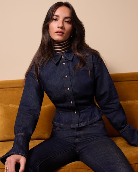 A woman wearing a long sleeve denim top and matching jeans.