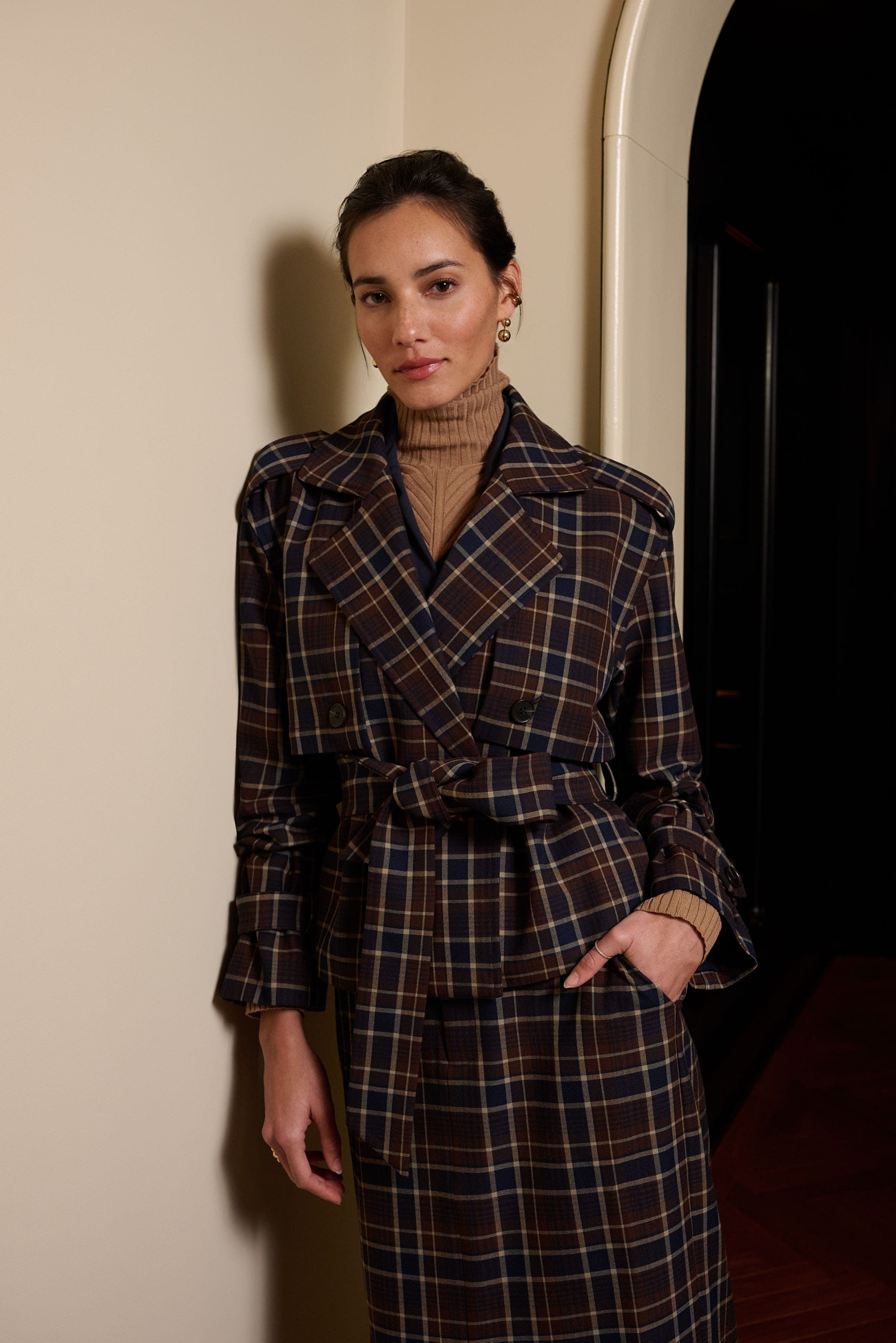A woman wearing a plaid trench coat.