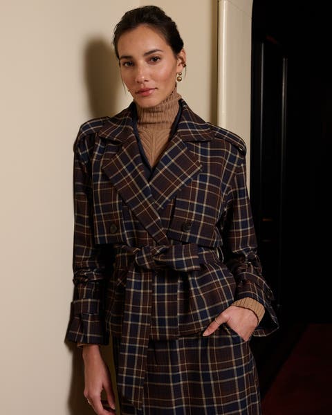 A woman wearing a plaid trench coat.