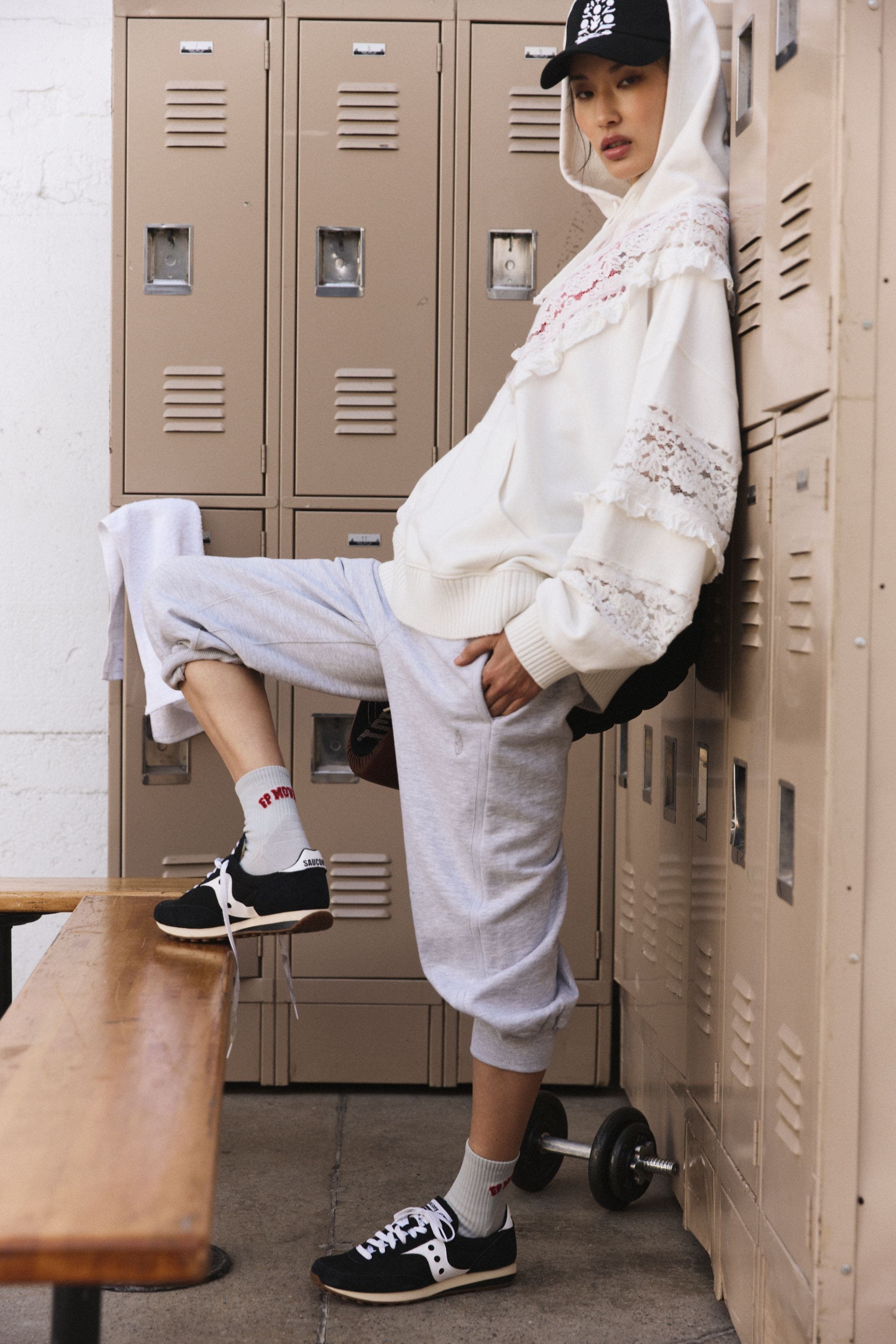 A woman wearing a lace-trim hoodie with sweatpants.