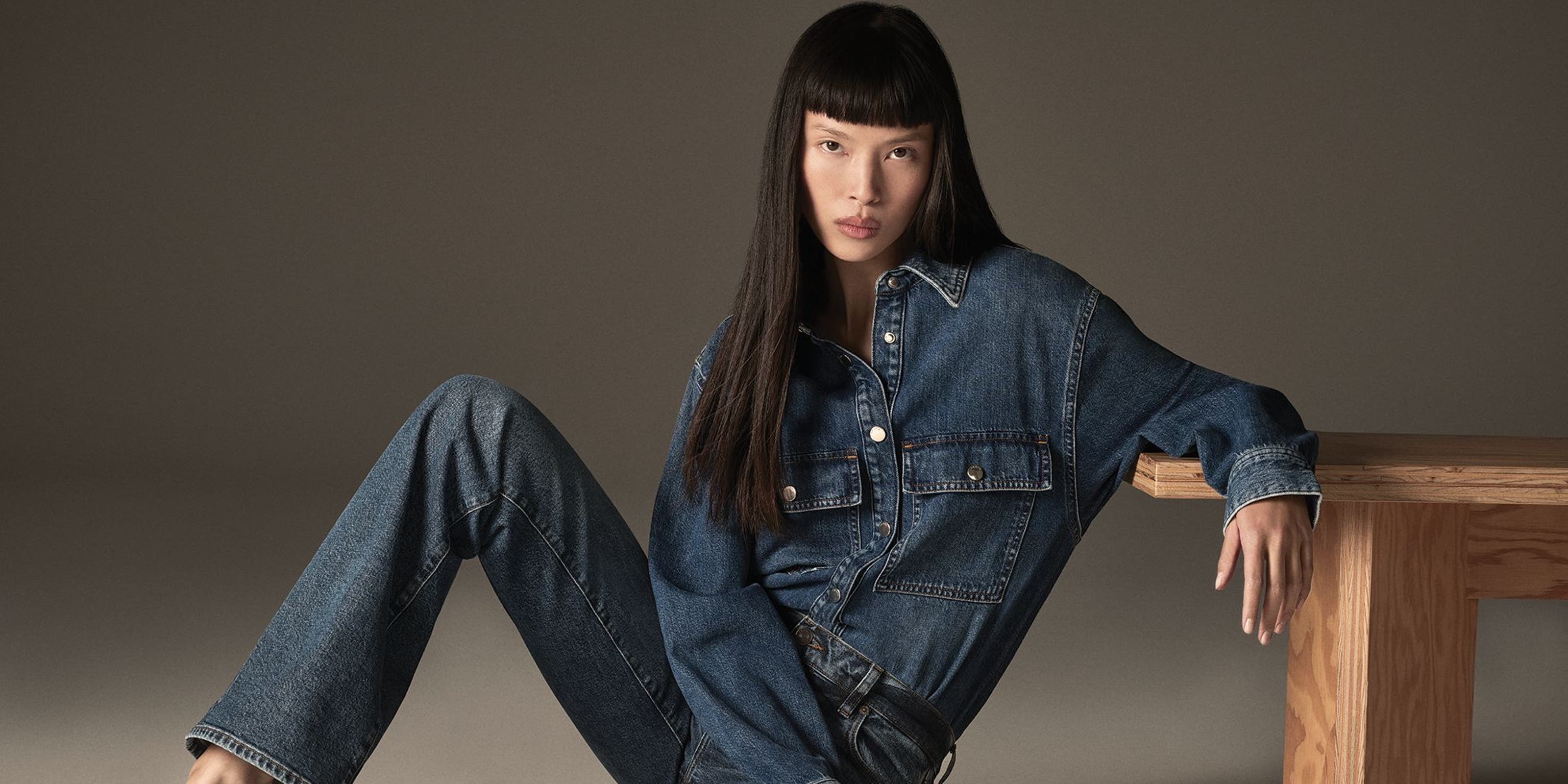 Woman wearing long sleeve denim shirt and denim jeans from FRAME.