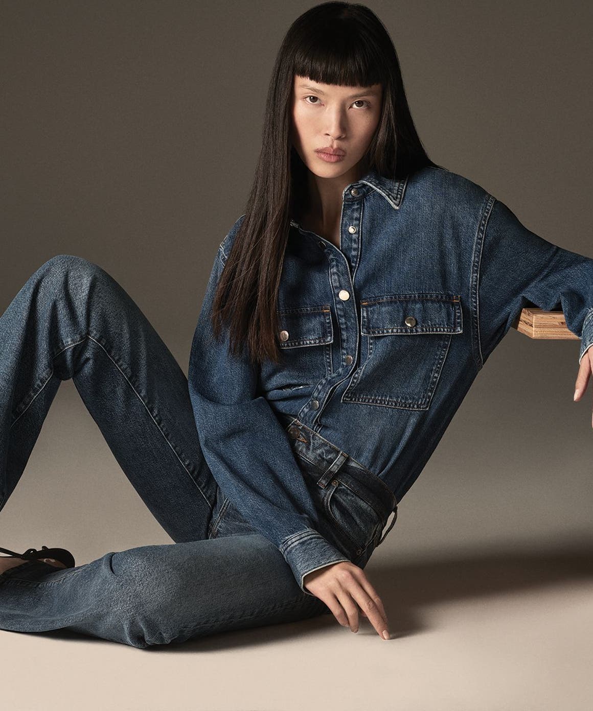 Woman wearing long sleeve denim shirt and denim jeans from FRAME.