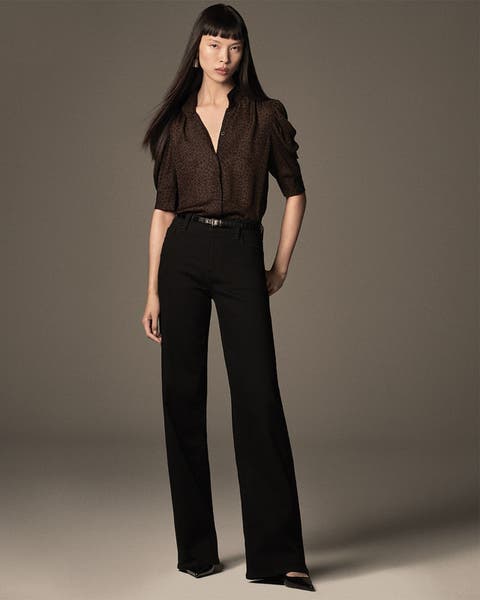 Woman wearing black jeans and dark brown animal print button up shirt