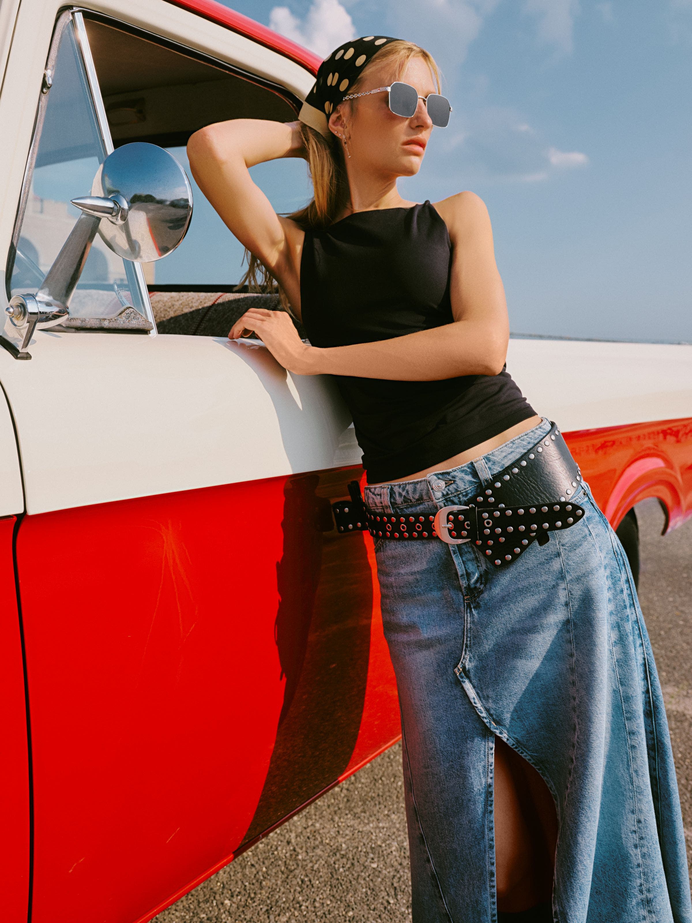 A woman wearing a tank top and denim skirt.