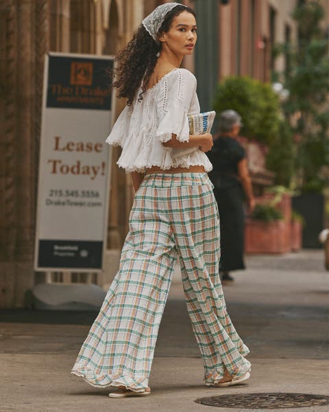 Model wearing Free People plaid pants and white blouse