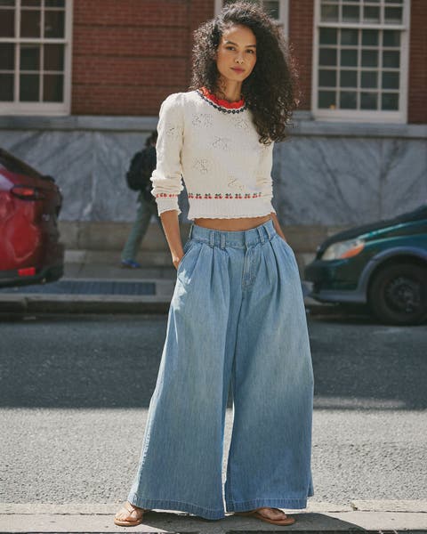 Model wearing We The Free denim pants and white sweater.