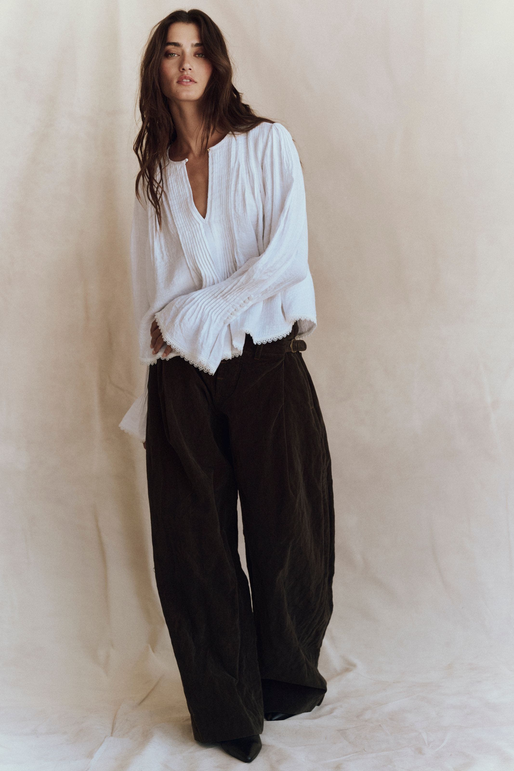 A woman wearing a white flowy blouse.
