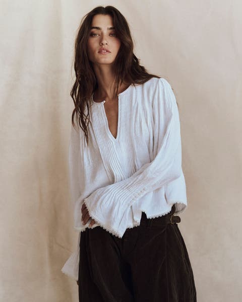 A woman wearing a white flowy blouse.