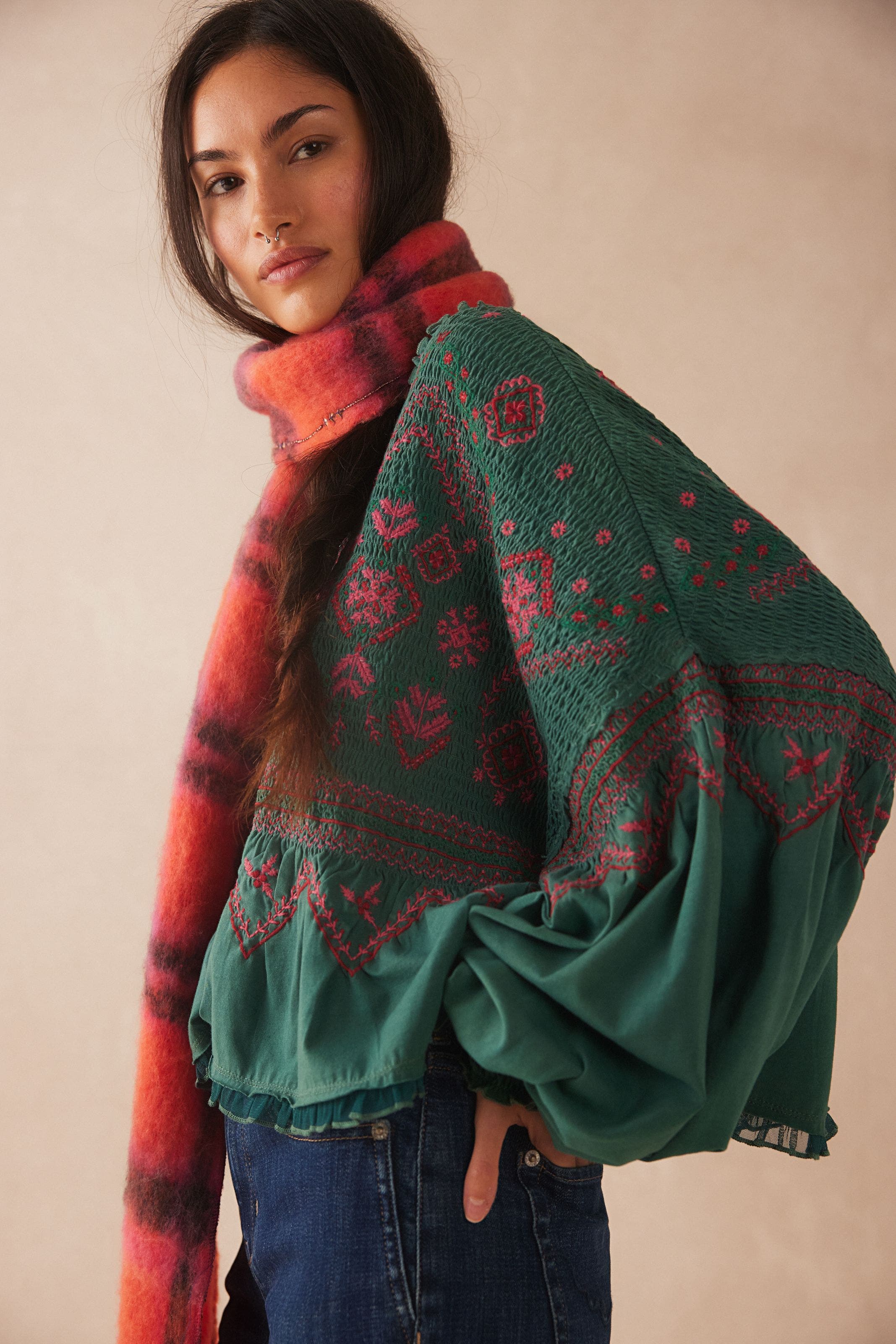 A woman wearing an embroidered smocked top.