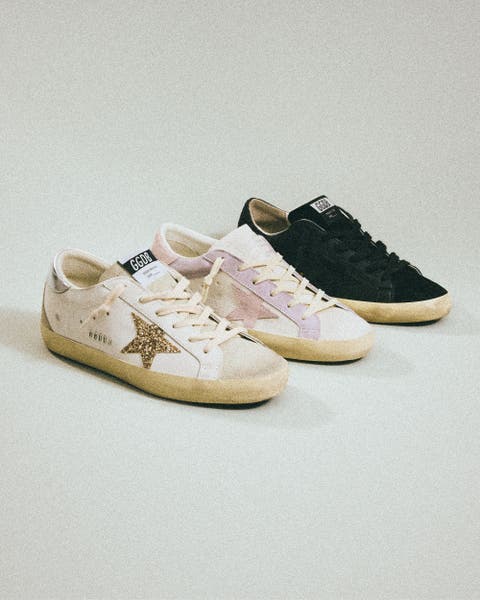 Three Golden Goose sneakers line up.