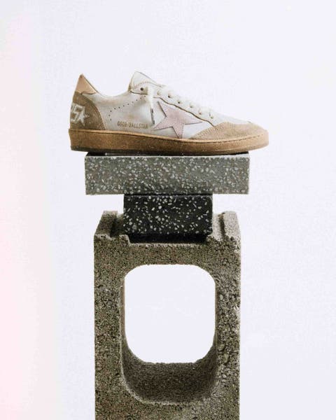 Golden Goose sneaker balance on stones.