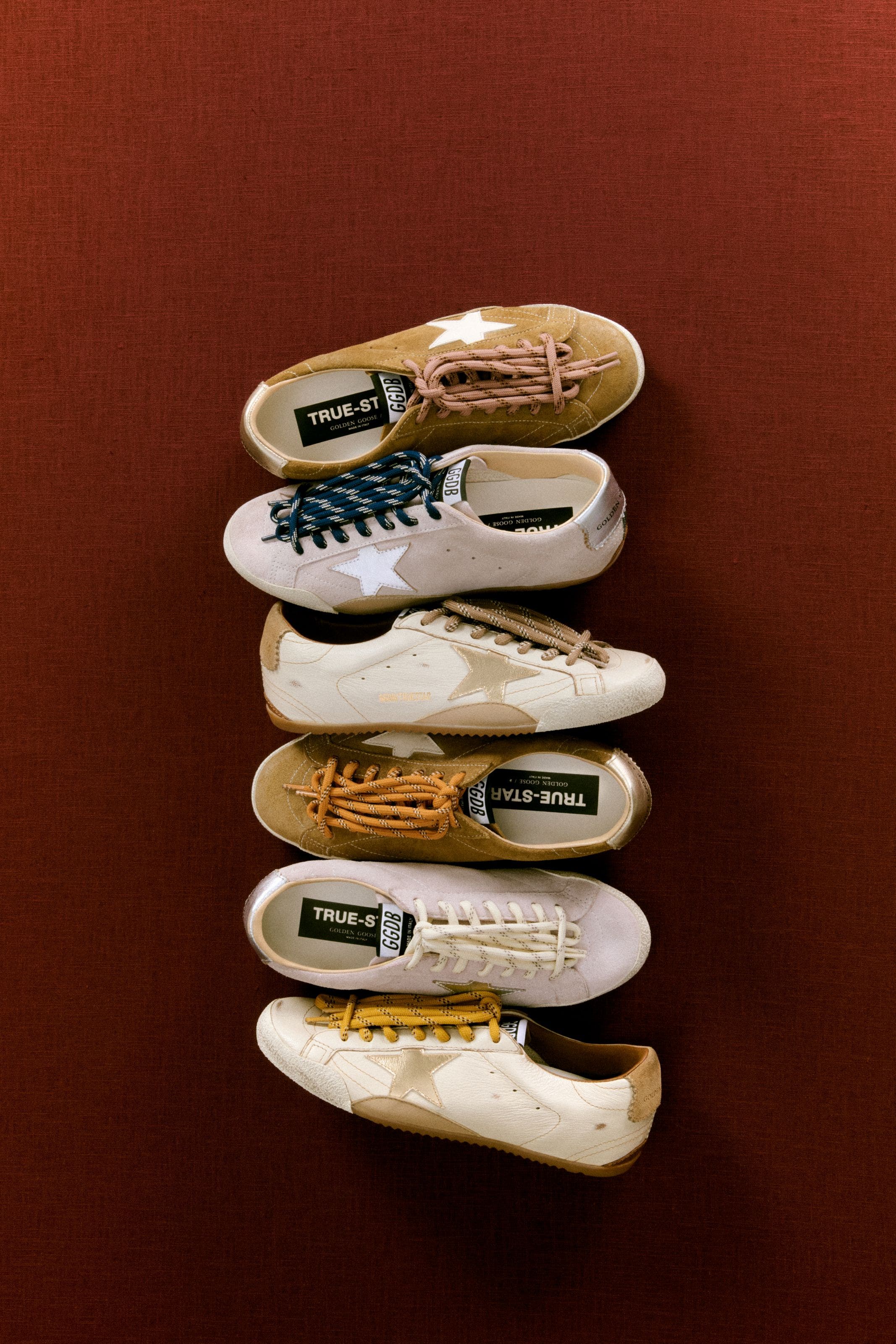 Six Golden Goose sneakers with star details and contrast laces stacked.