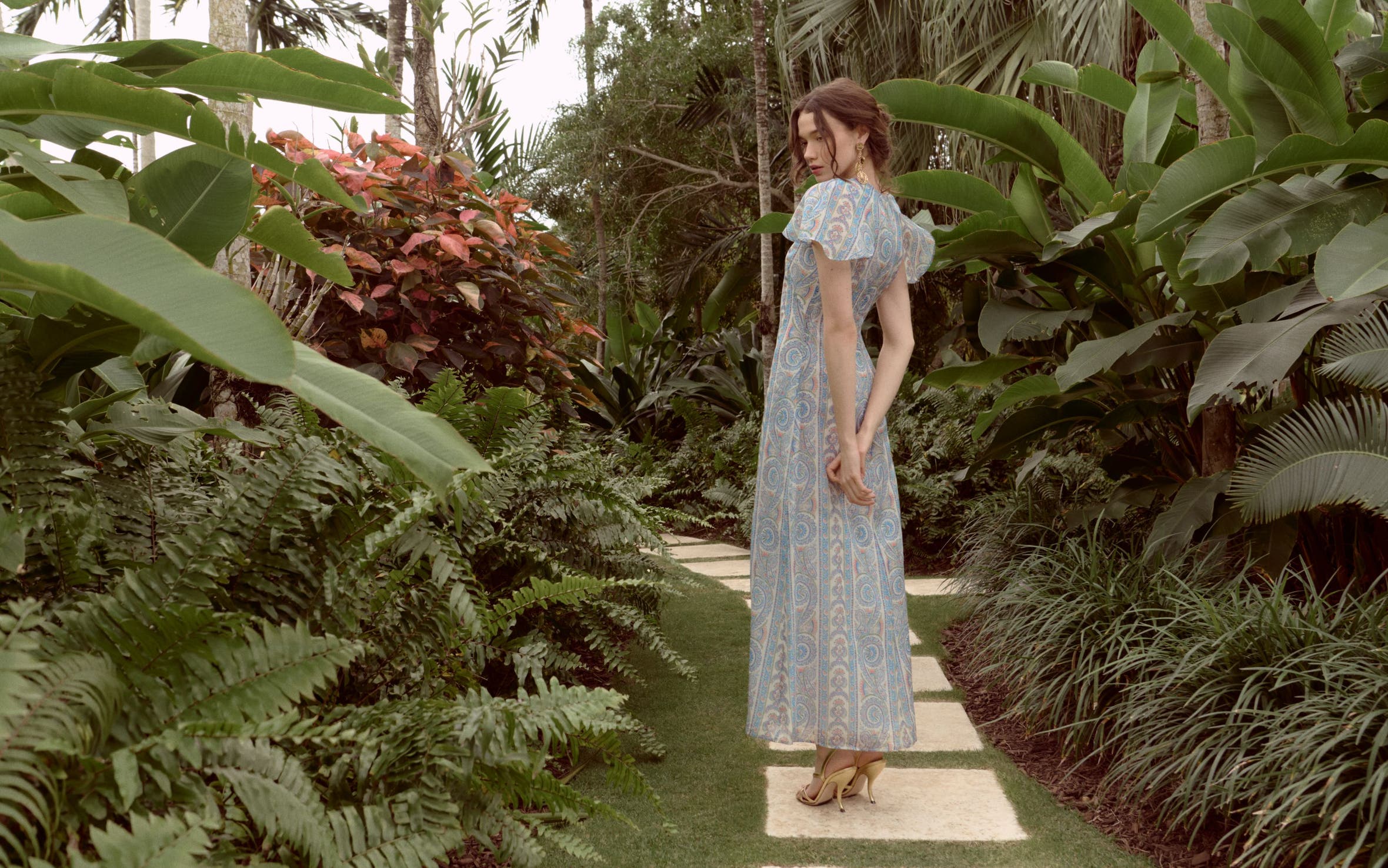Woman wearing a printed gown from Hill House Home.