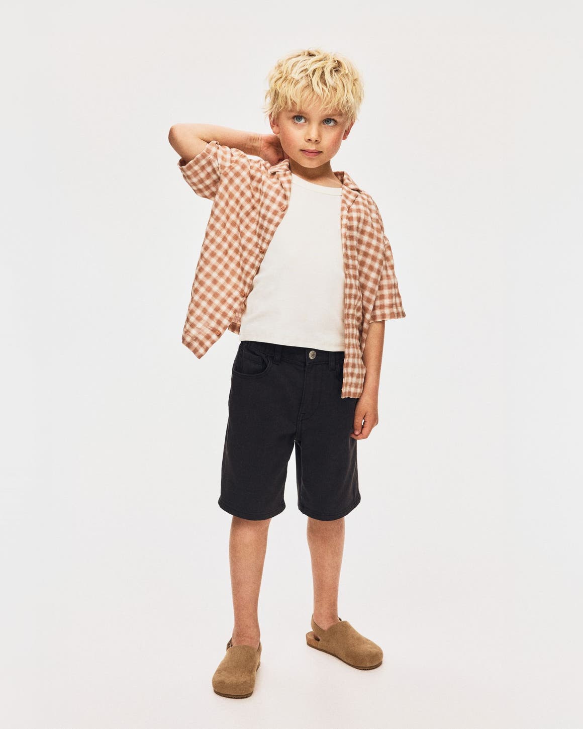 A boy wearing a plaid shirt and shorts from H&M.