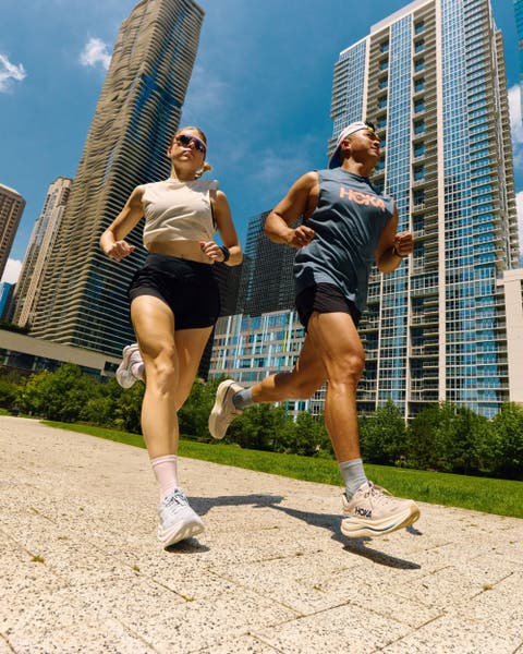 Two people running wearing Hoka shoes.