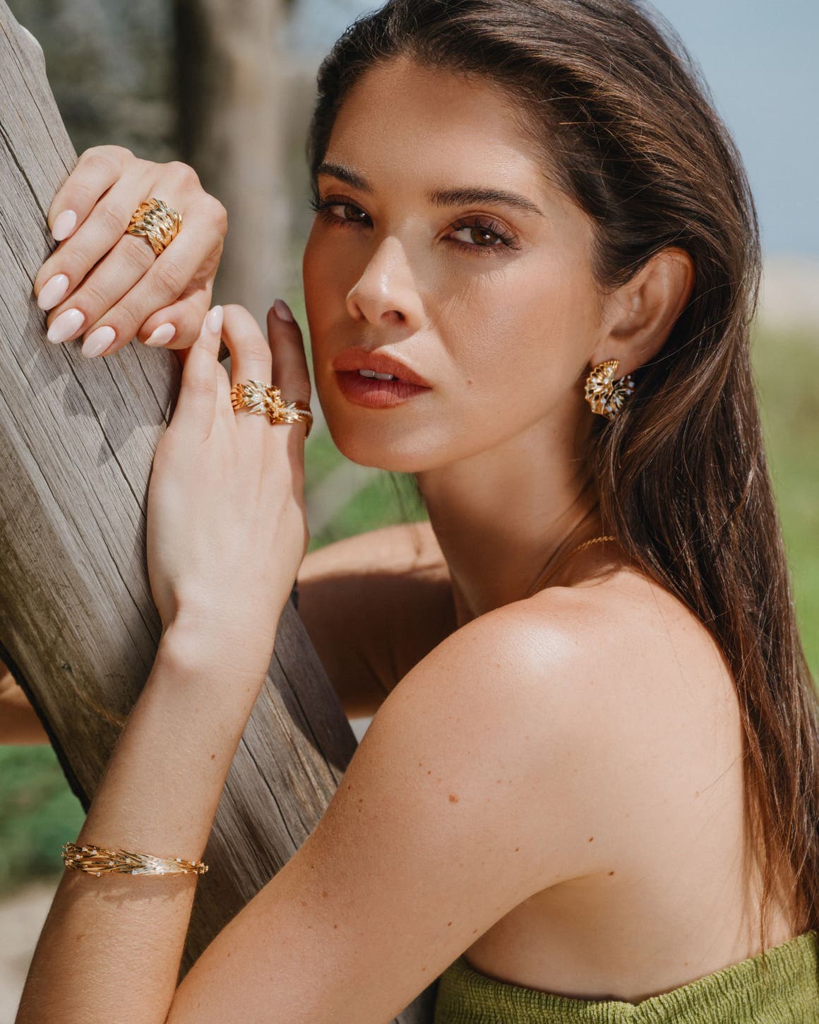 A woman wearing Hueb earrings, rings and bracelet.