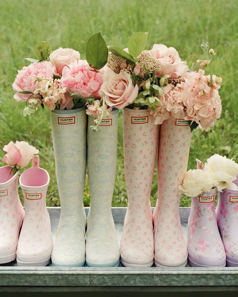 Hunter boots with flower bouquets in them.