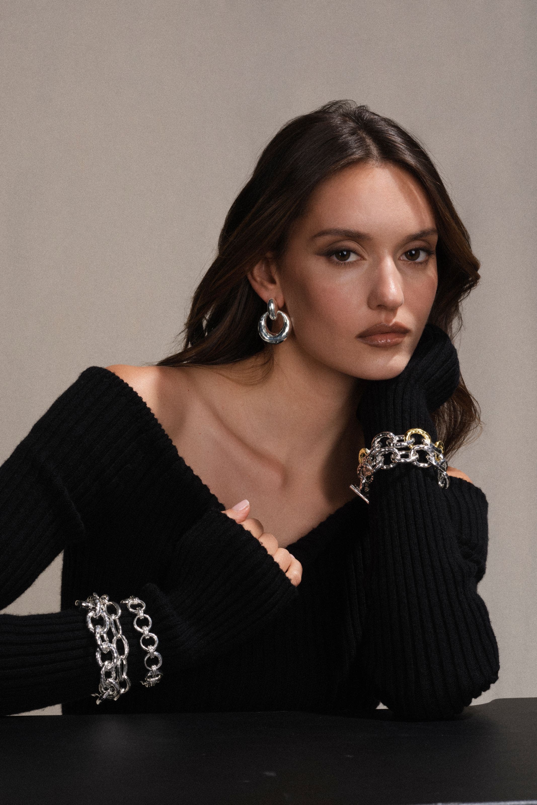 A woman wearing earrings, a necklace and bracelets.