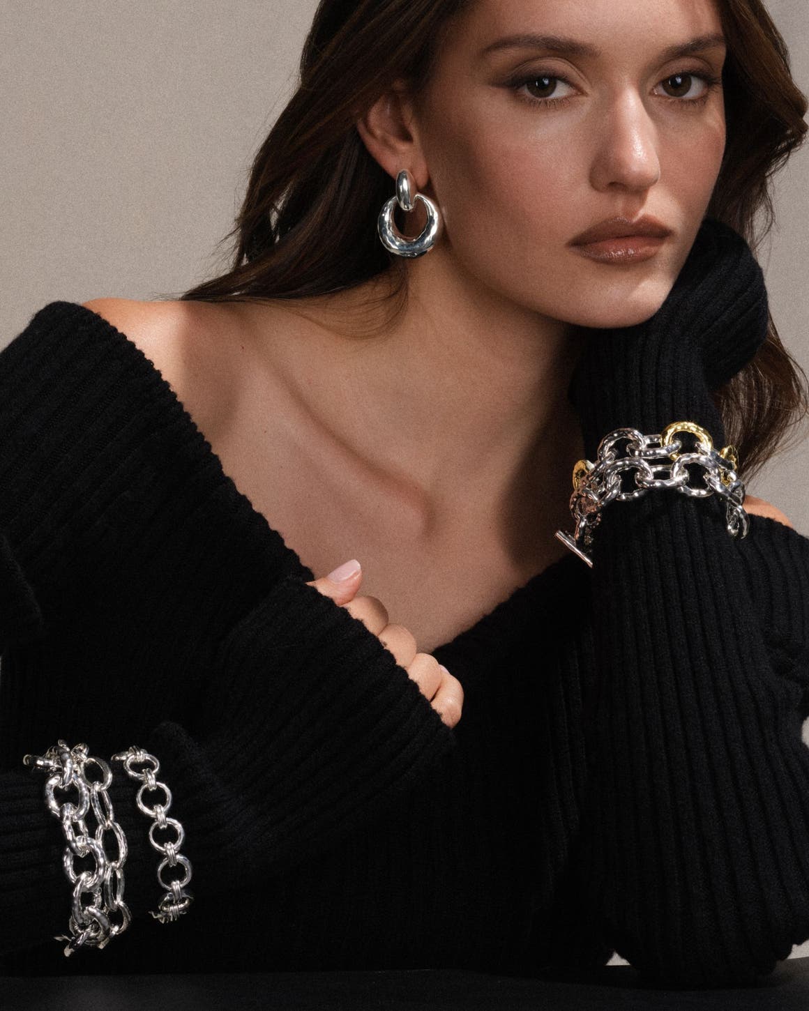 A woman wearing earrings, a necklace and bracelets.