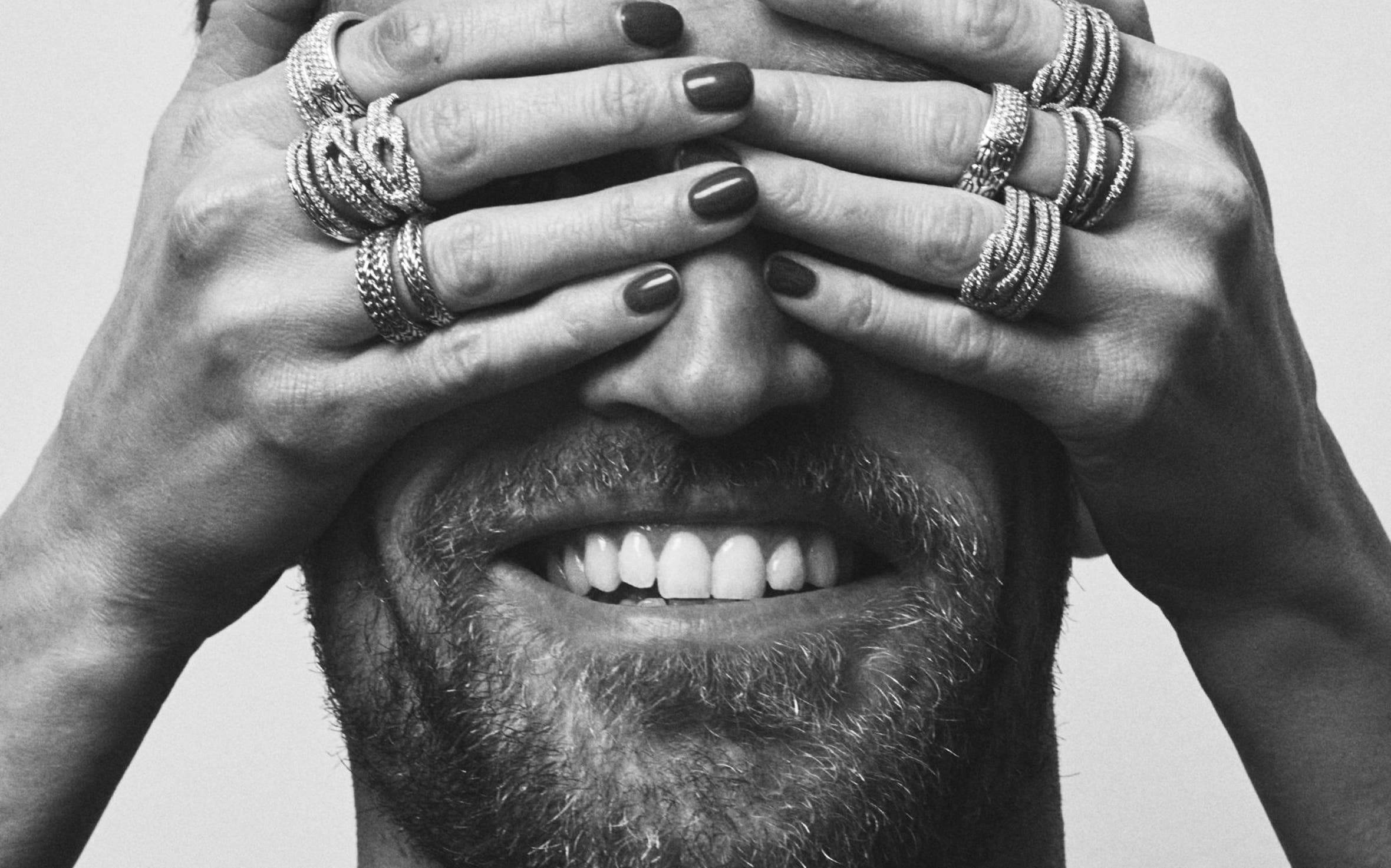 A man whose eyes are covered by a woman's hands.
