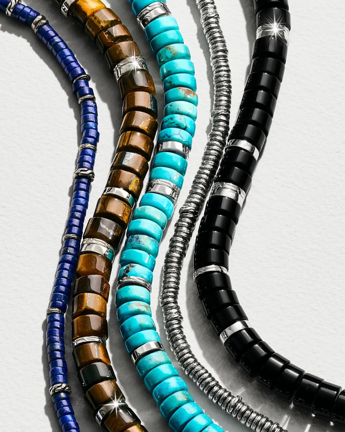 A row of beaded necklaces in different colors and textures.
