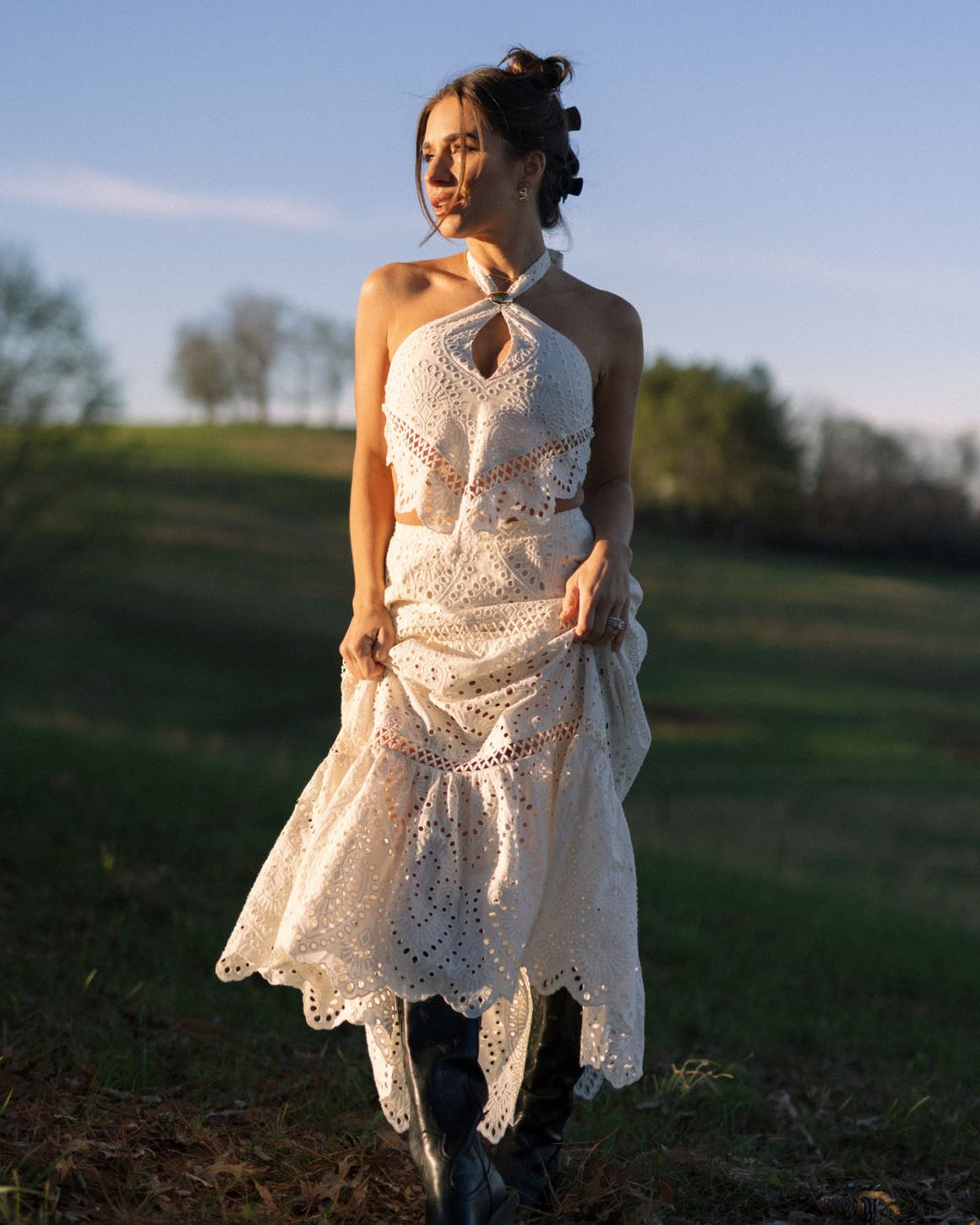 A woman wearing a matching white eyelet top and maxi skirt.