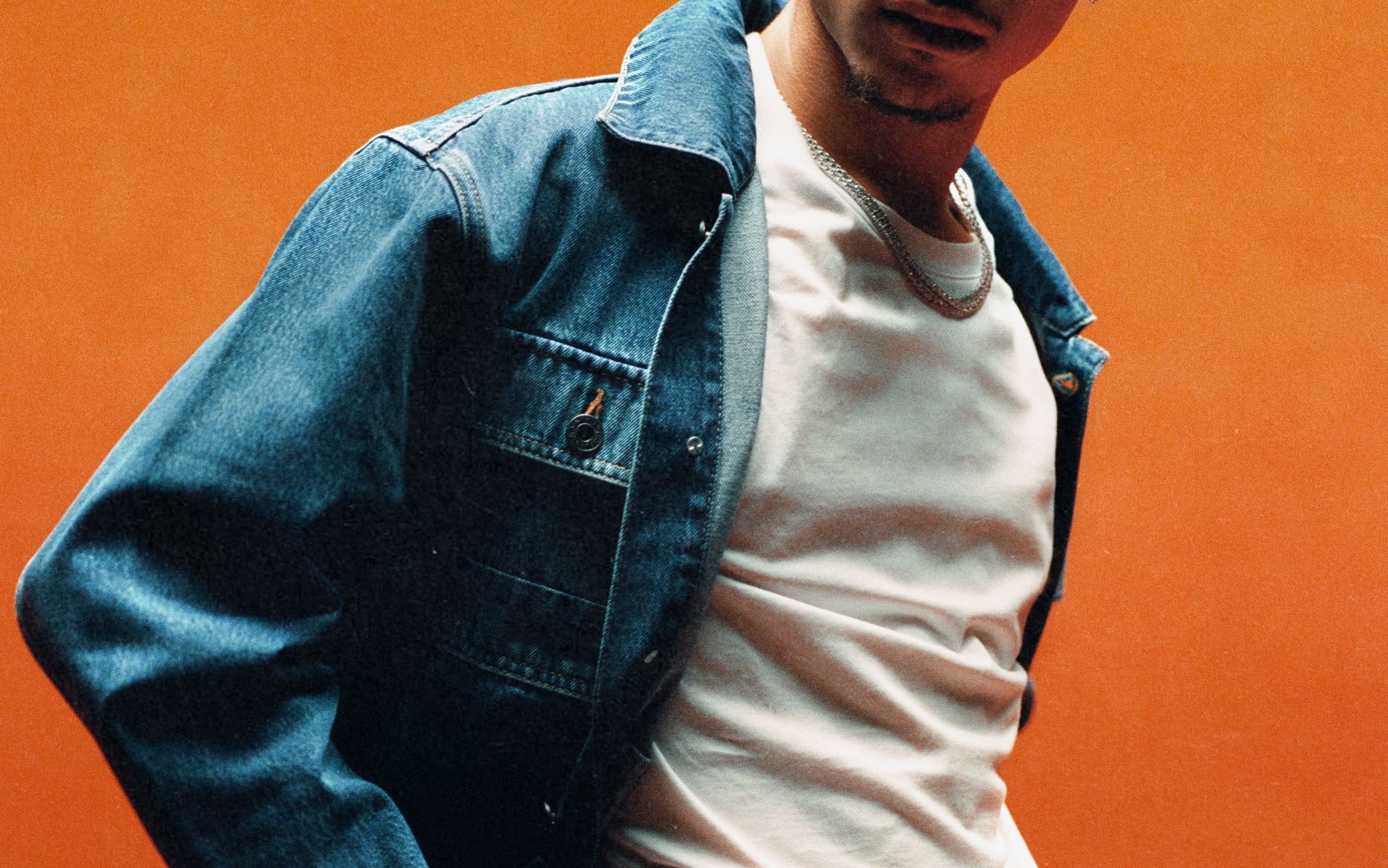 A man in white tee, jeans and a denim jacket from Off-White’s new line.