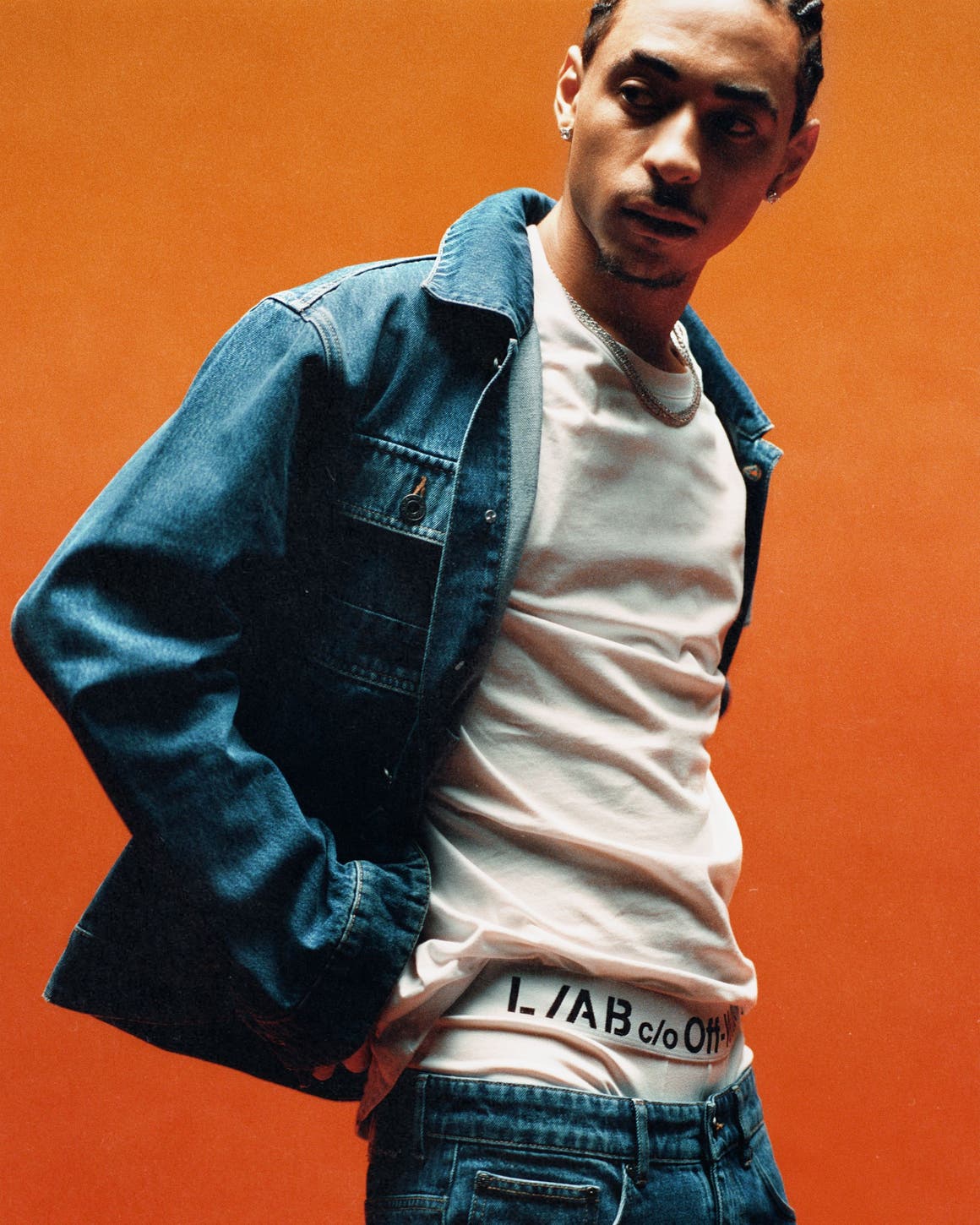 A man in white tee, jeans and a denim jacket from Off-White’s new line.