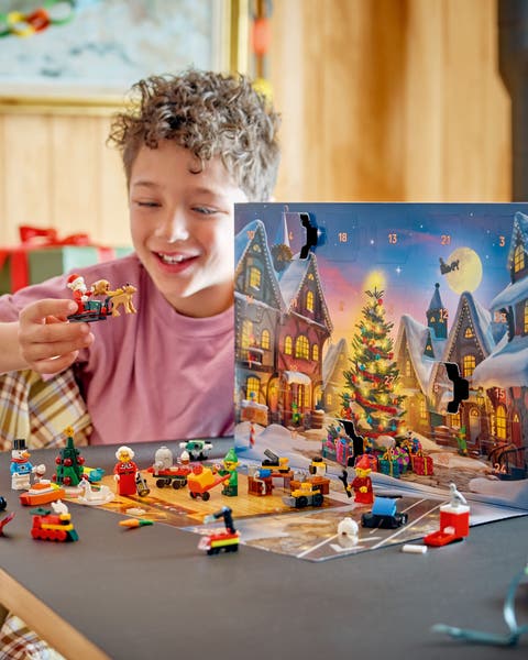 A boy playing with a LEGO Christmas set.