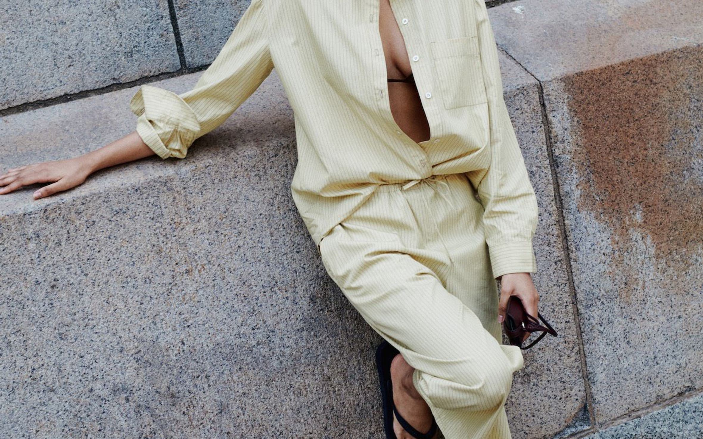A woman wearing a matching butter yellow shirt and pants set.