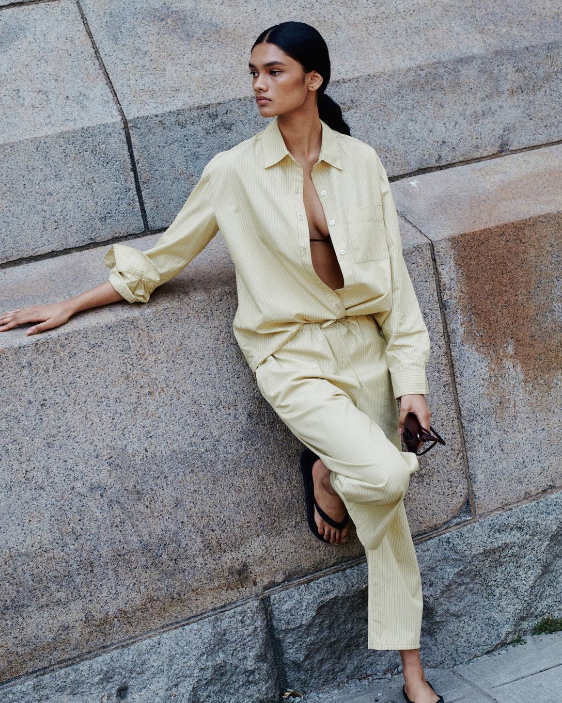 A woman wearing a matching butter yellow shirt and pants set.