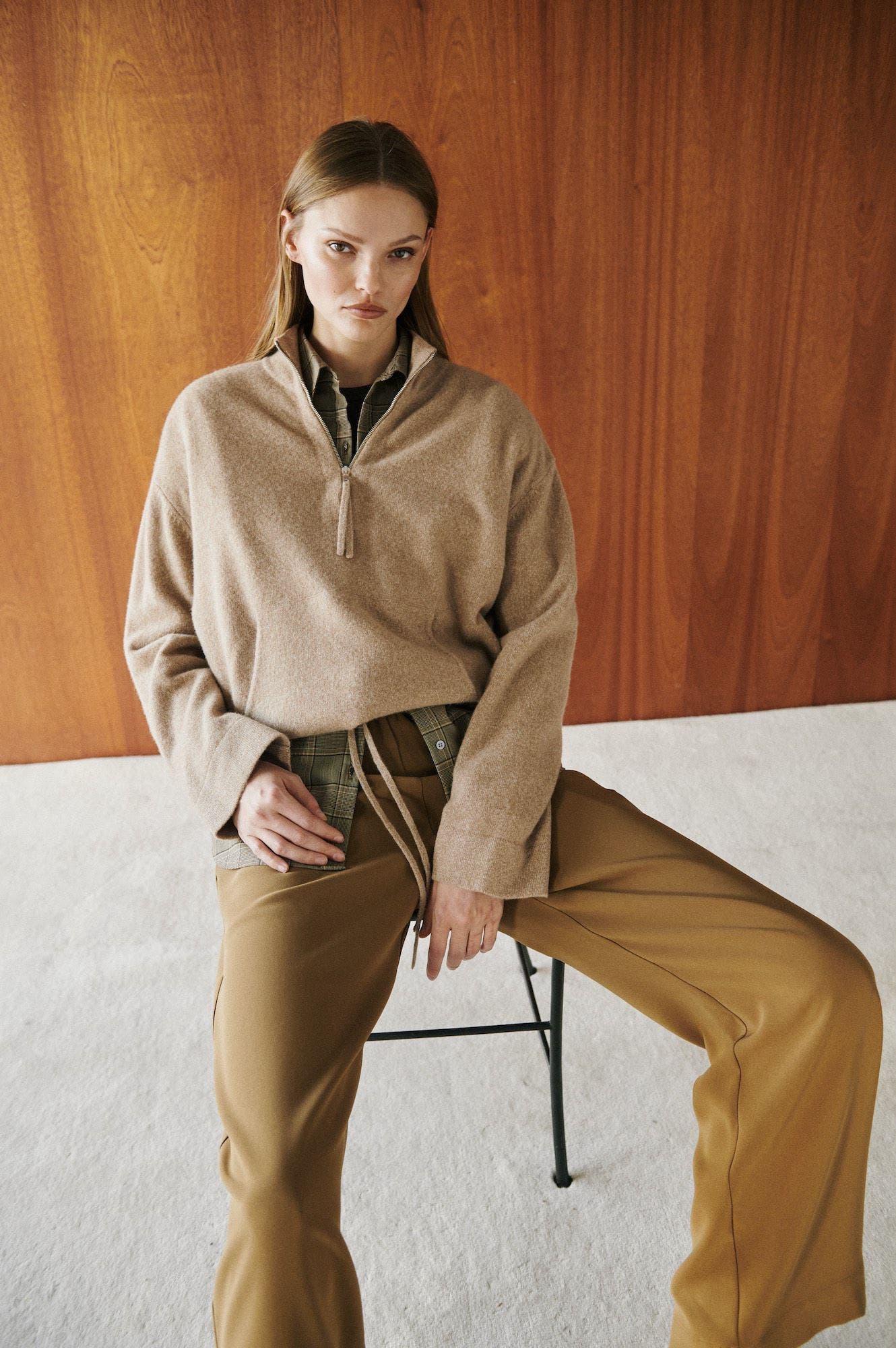 A woman wearing a half zip sweater over a button up shirt.