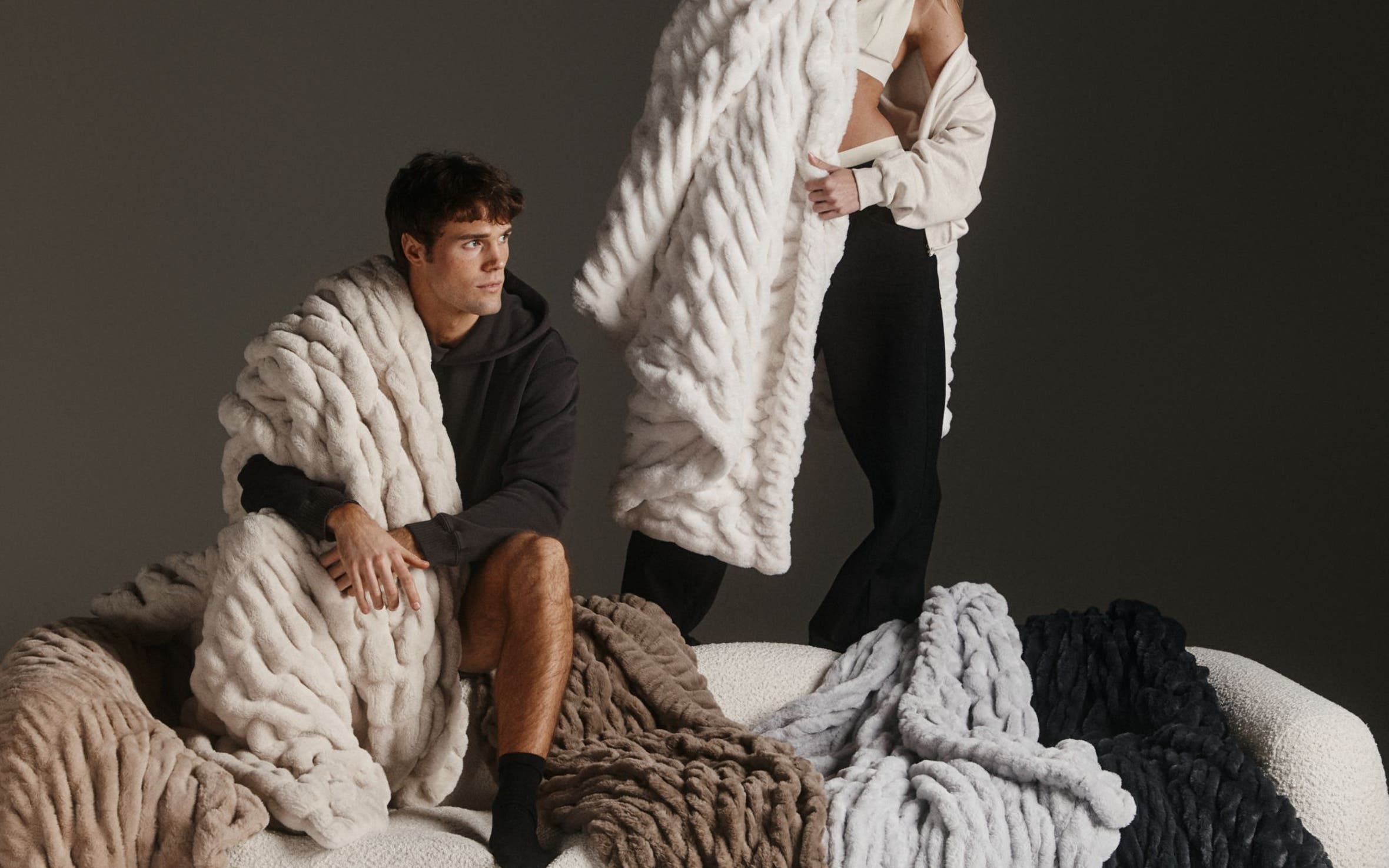A man and woman surrounded by Lola Blankets.