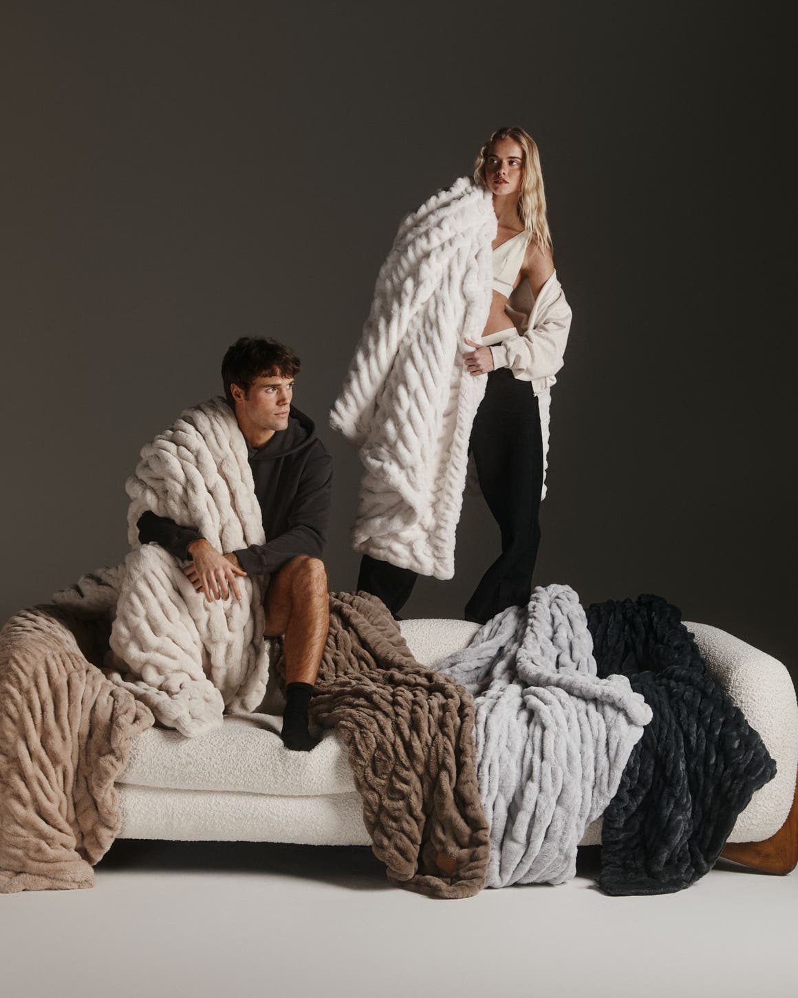 A man and woman surrounded by Lola Blankets.