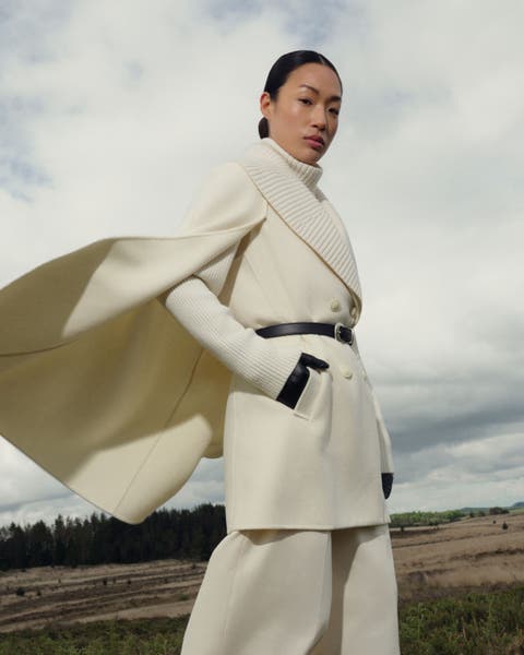 A woman wearing a cream wool Mackage cape coat.